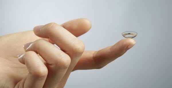 Woman about to put a contact lens in her eye after having cleaned it