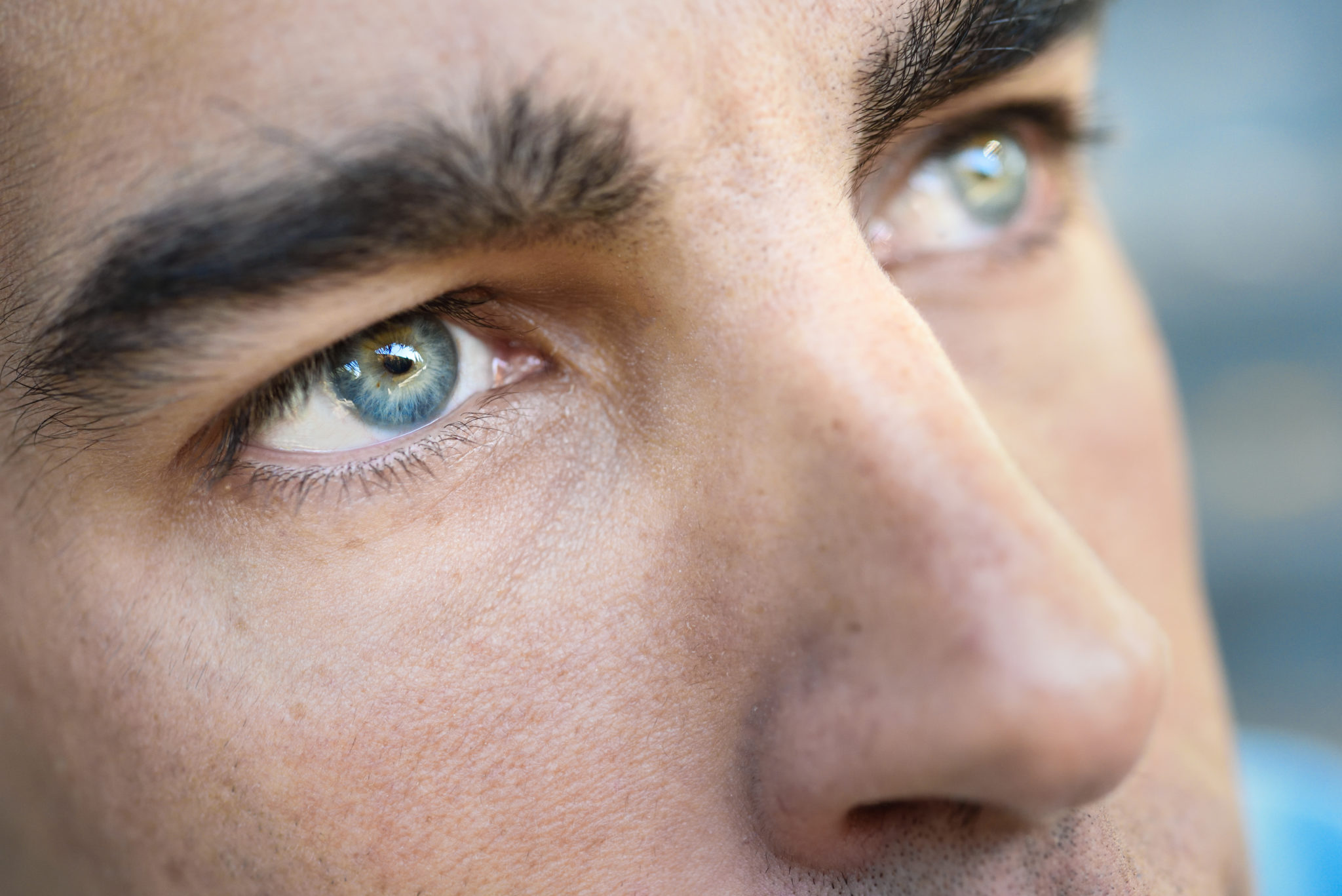 Close-up shot of man's blue eyes as he looks at something his friend pointed at