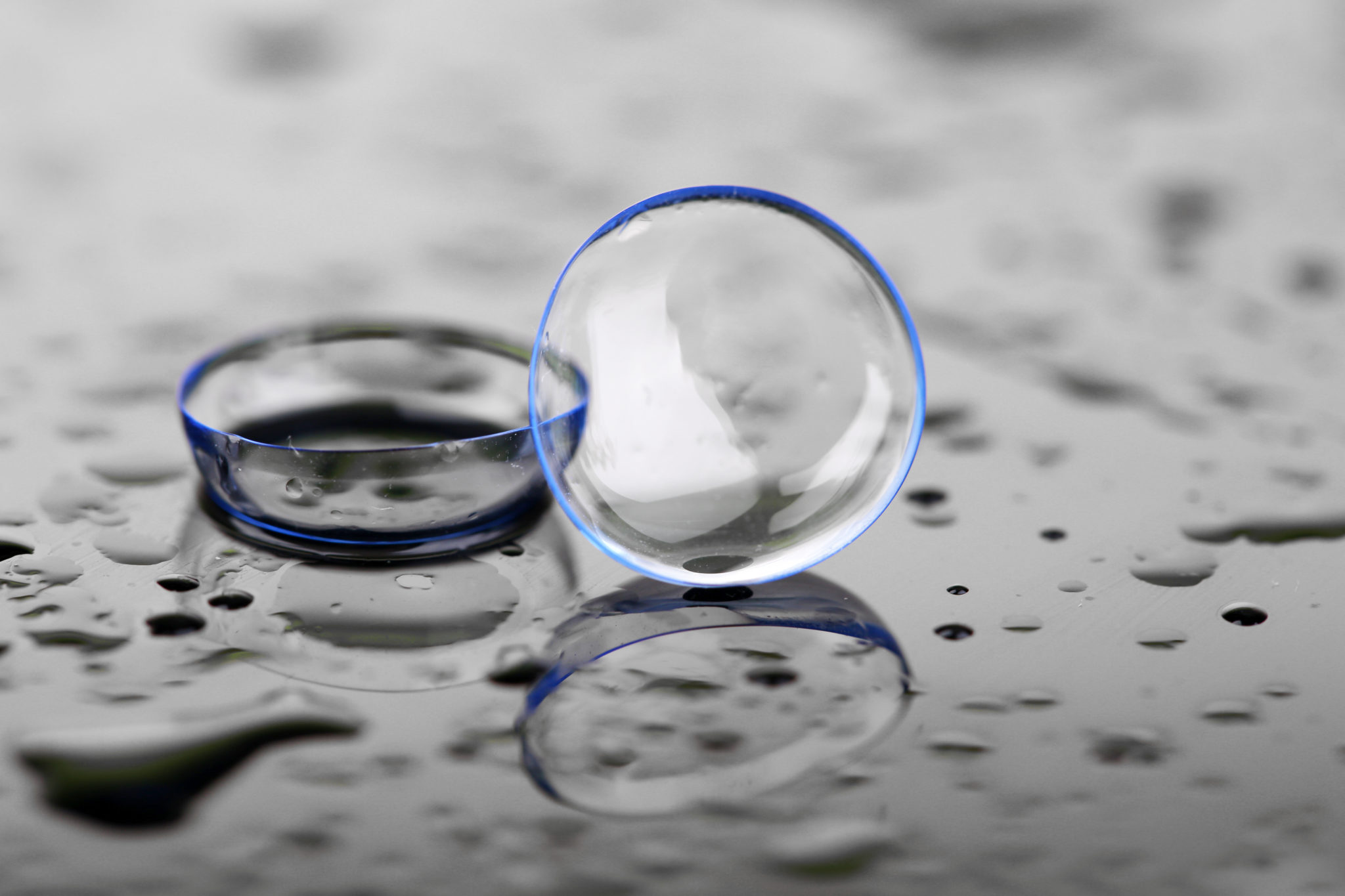 Contact lenses with water drops on bright background after they have been cleaned