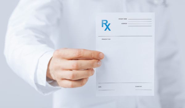 Close up of male doctor holding rx paper in hand